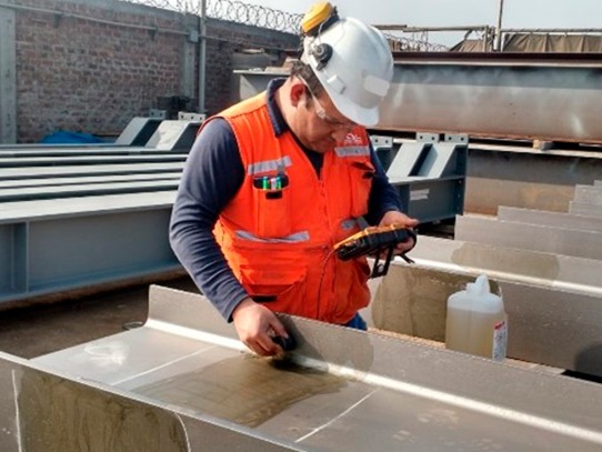 Técnico aplicando ensayo de líquidos penetrantes sobre una unión soldada